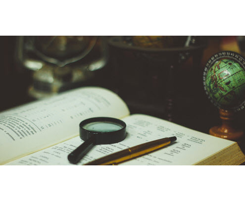magnifying glass sitting on top of book