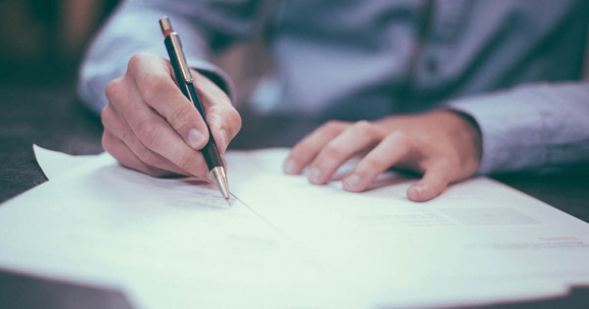 man writing on paper